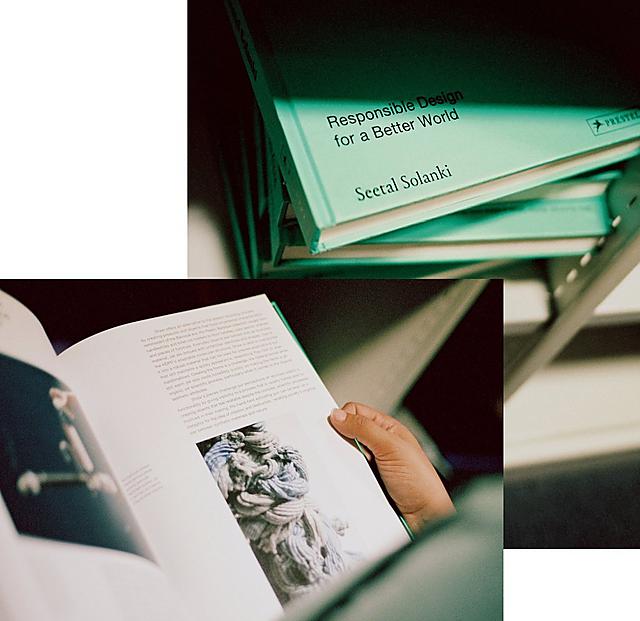 A woman is reading the page of a pastel green design book. 