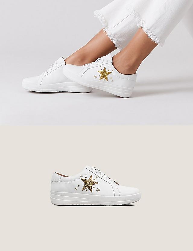 White leather Tennis style sneakers with gold embellished star print on the side and laces.