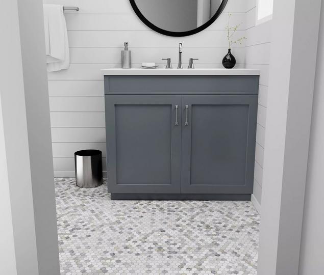 Marble bathroom with gray and white marble mosaic flooring, black round mirror, and a gray vanity.