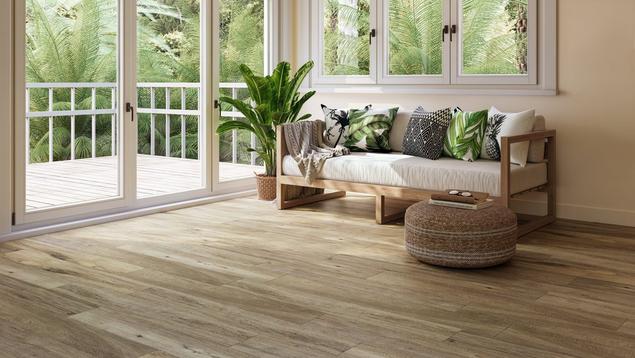 Sitting room with light brown waterproof flooring and a coastal-style couch. 