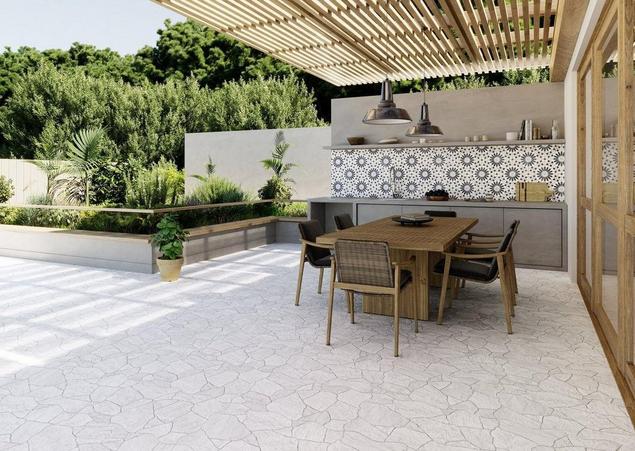 Outdoor kitchen with exposed portico overhang and dining area
