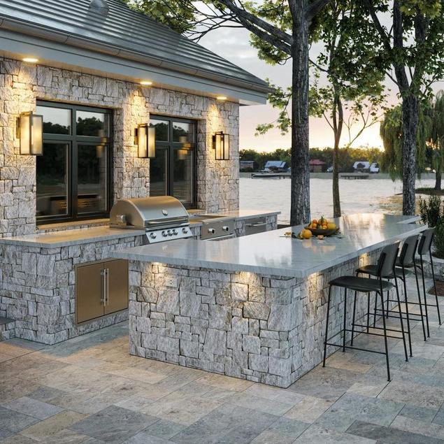 Outdoor patio and kitchen with stacked stone ledger walls and counters