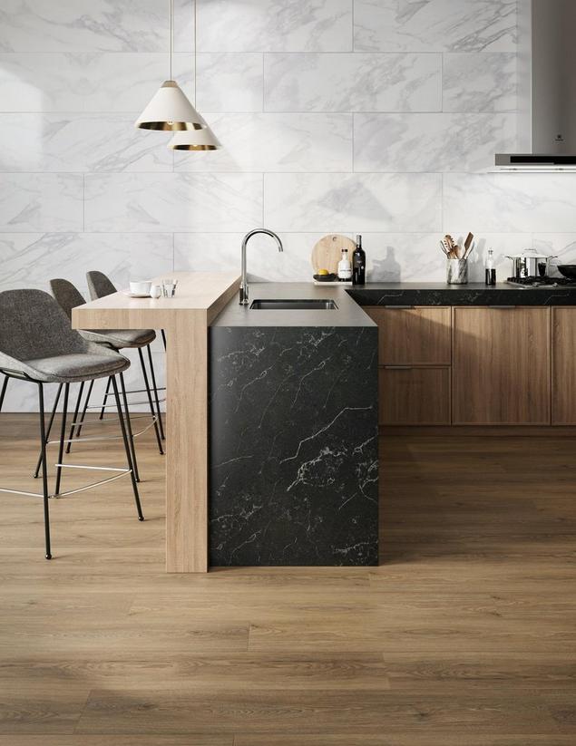 Kitchen with black countertops, white wall tile, and brown wood-look DuraLux Performance flooring.