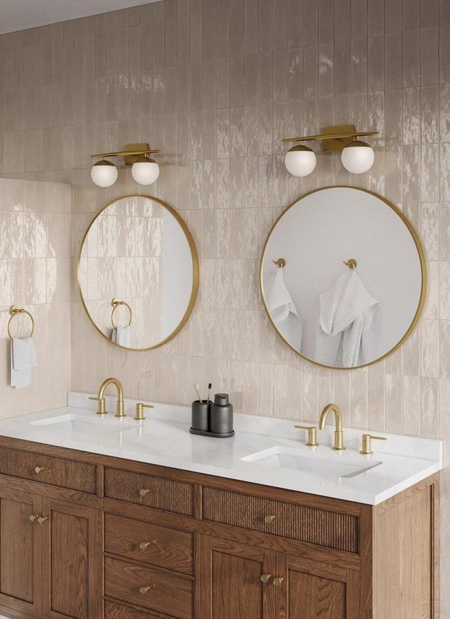 Overhead bathroom view of white vanity top, gold faucet hardware, and white and green marble mosaic.