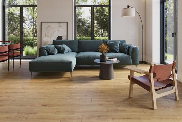 White living room with green couch and medium brown wood-look Optimax Performance flooring.