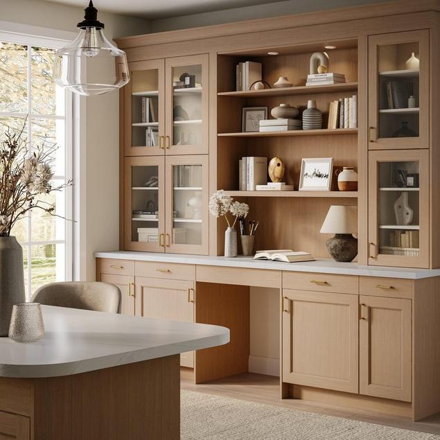Home office close-up of light blonde wood cabinets with gold hardware.