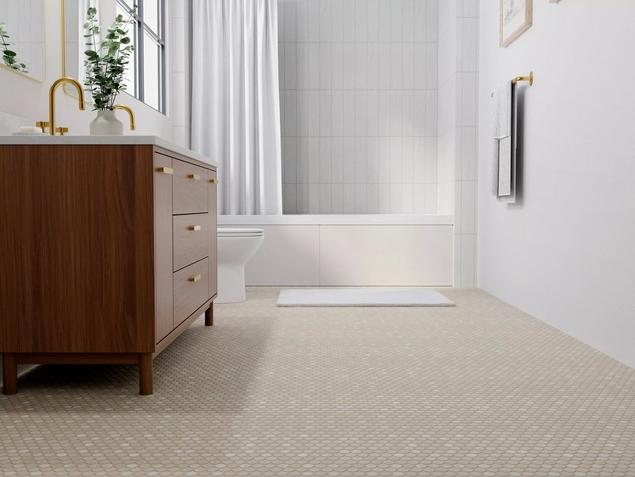 A white bathroom with beige penny tile flooring.
