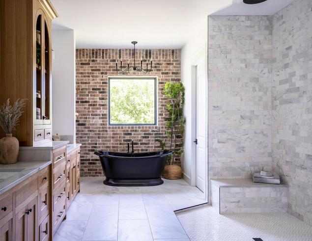 Bathroom with marble tile and brick wall.