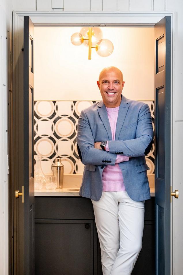 Creighton smiling by the entry doors of his million-dollar listing. 
