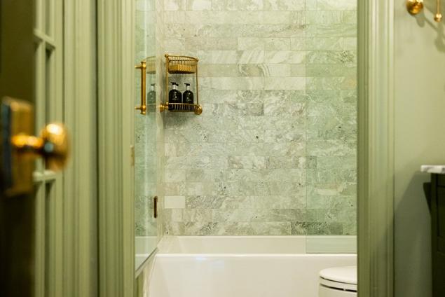 Close-up of green marble shower wall tile in the primary bathroom.