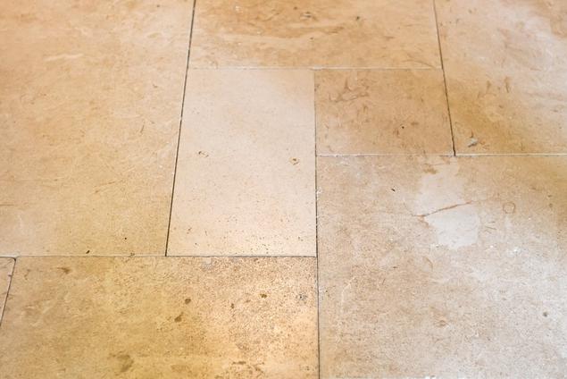 Close-up of limestone paver flooring arranged in a French lay pattern. 