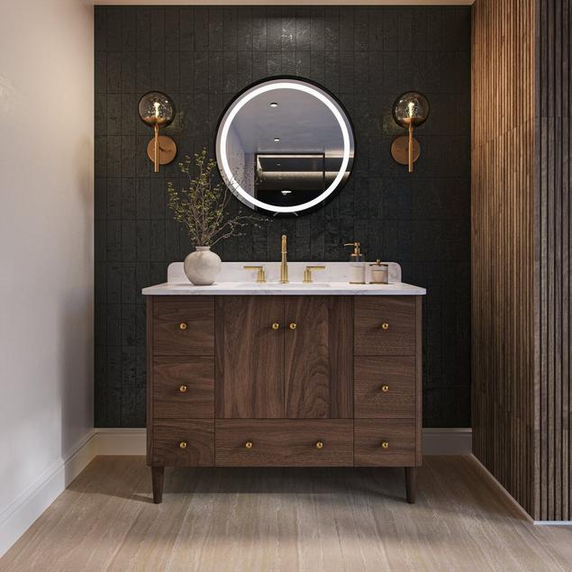 Bathroom with walnut vanity, slate backsplash, gold sconces, and matte beige porcelain floor tile.