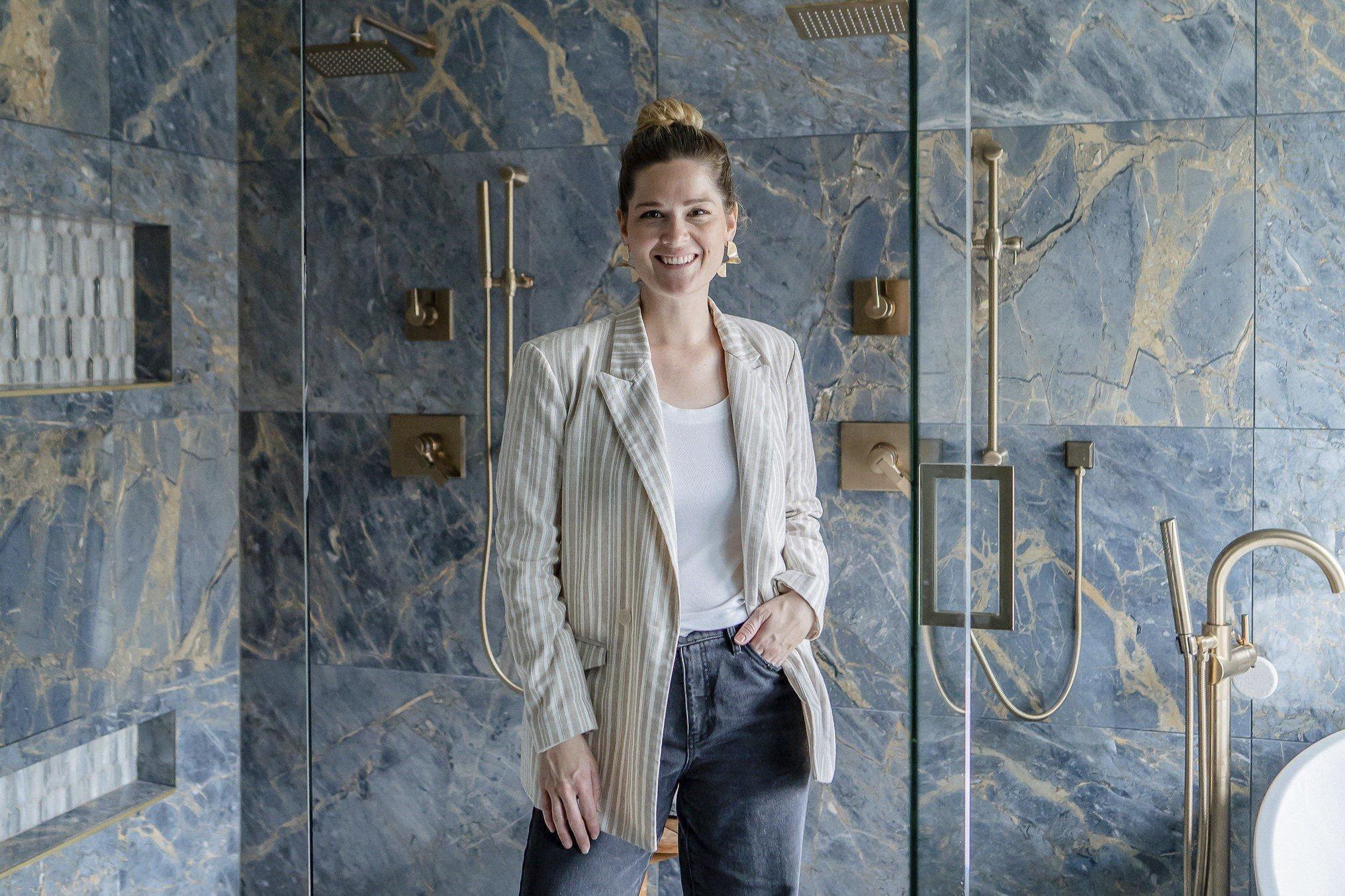 Sheila, owner of Olivia Hail Designs, posing with newly remodeled bathroom.