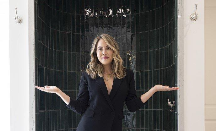 Chloe posing in front of her green decorative tile shower.
