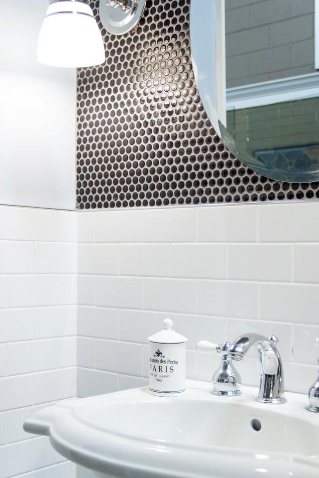 Bathroom with white sink, white subway wall tile, and black penny tile backsplash.