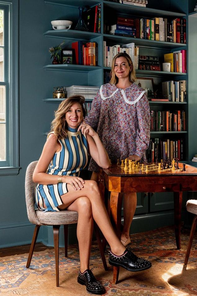 Portrait of two stylish female interior designers in a library. 
