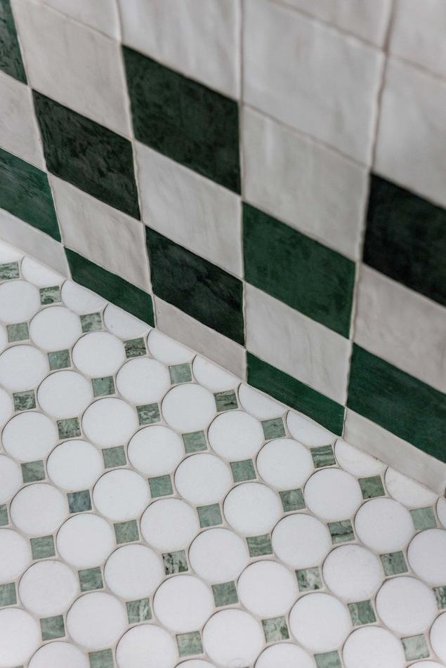 Checkerboard zellige wall tile and green marble mosaic floor.