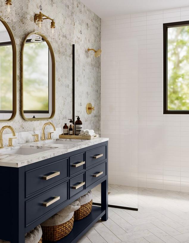 Marble bathroom with blue single vanity, white herringbone floors, gold light fixtures, and faucets.