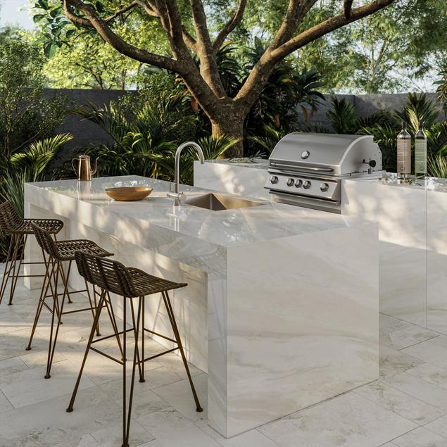 Outdoor kitchen with white marble countertop and floor tile.