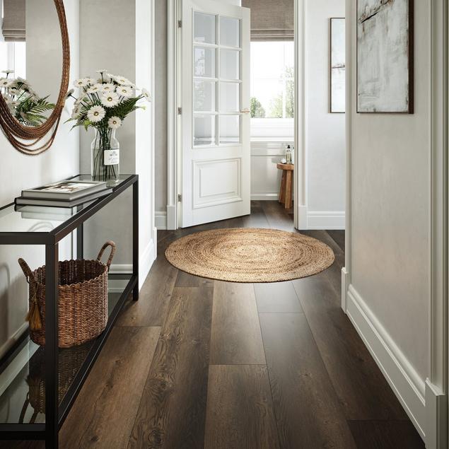 Entryway with white walls and dark brown wood-look vinyl flooring.