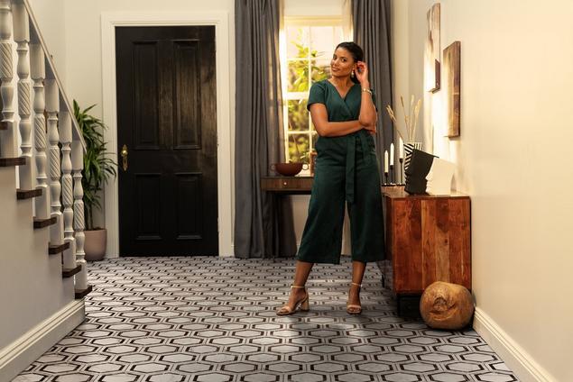 Woman in home entryway with black and white hexagon marble-look tile.