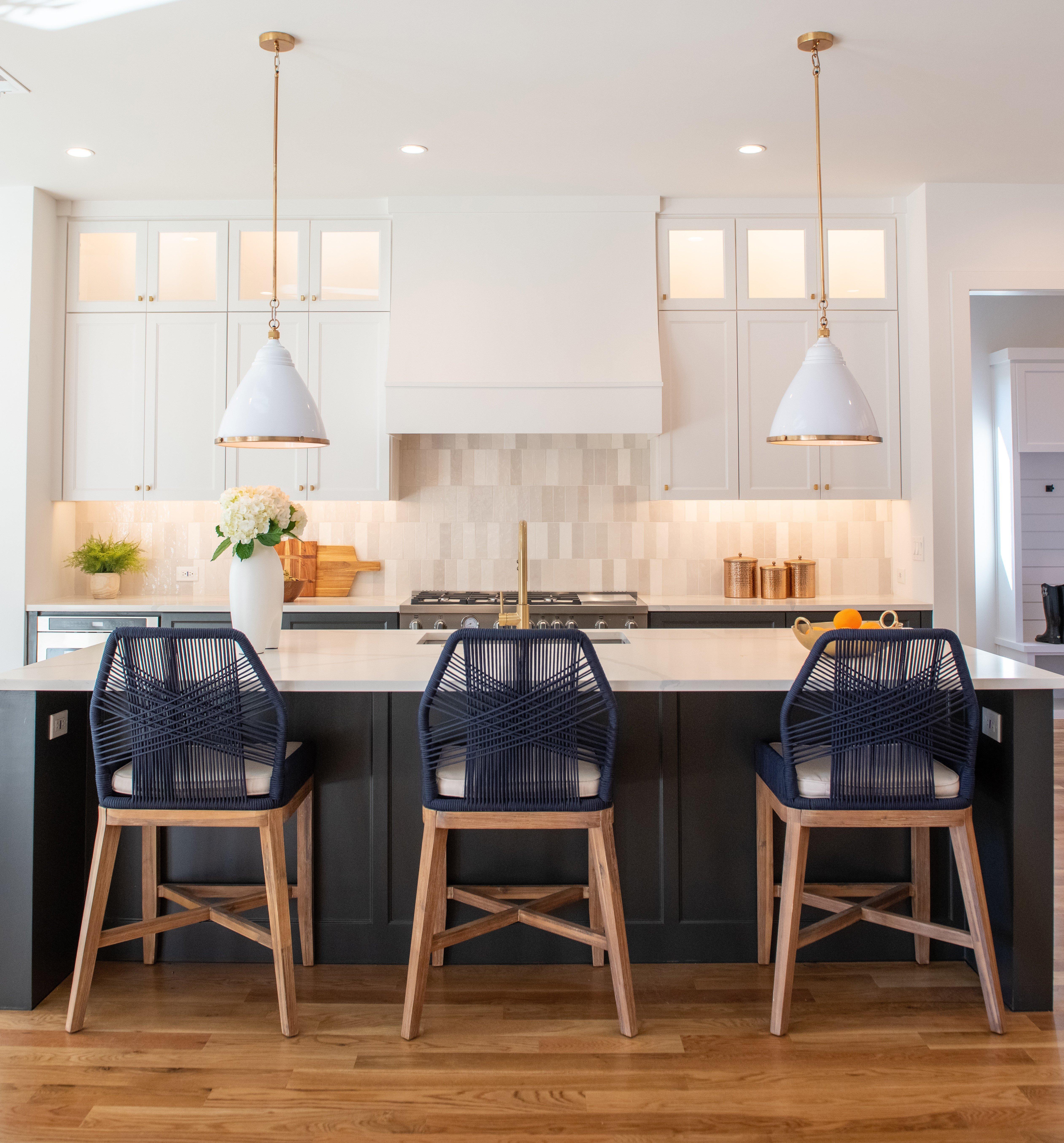 Kitchen with white backsplash tile, marble countertops and hardwood floors