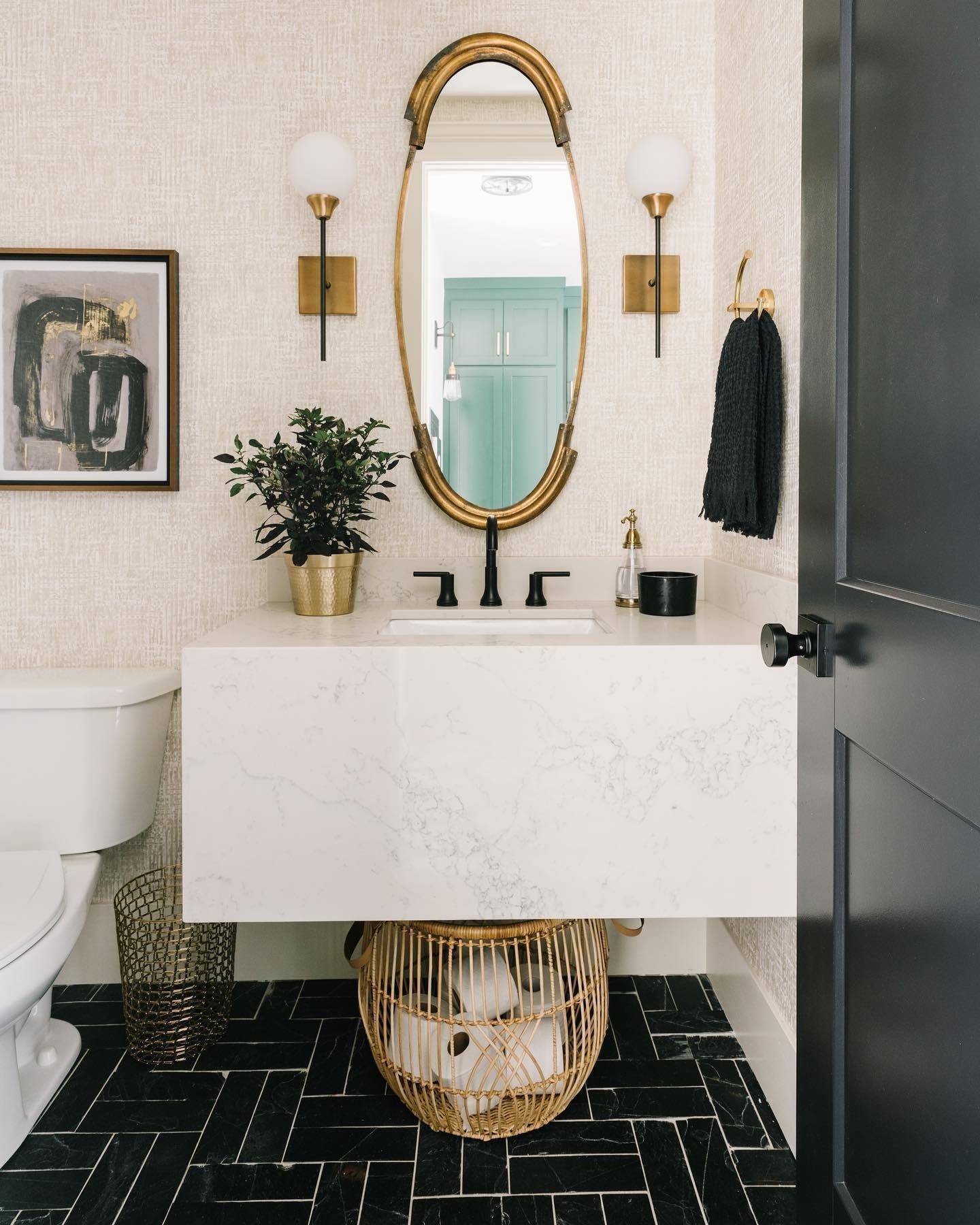 Bathroom with black marble tile floors, white marble vanity & gold hardware