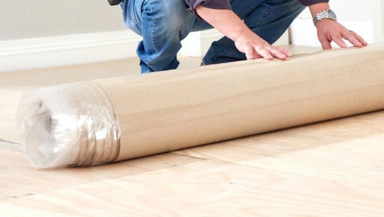 The Best Underlayment for Every Type of Flooring Man rolling out underlayment