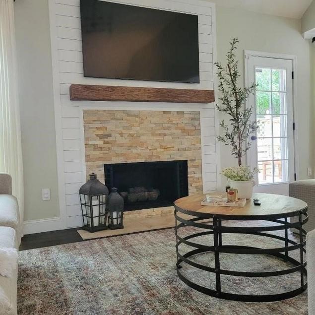 A brick fireplace with tv over mantel