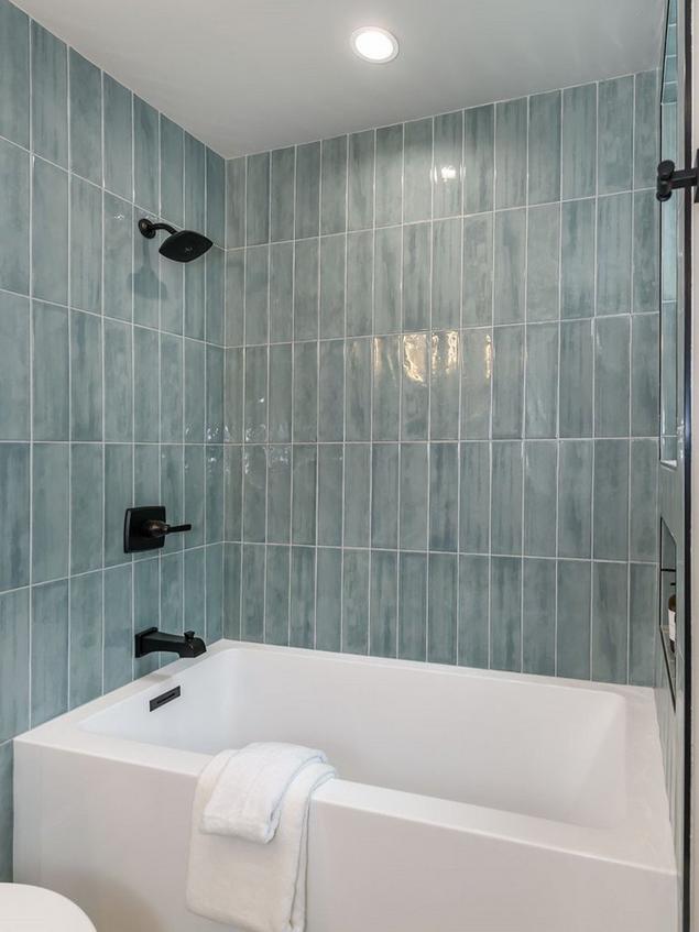Close-up of a guest bathroom featuring blue shower wall tile.