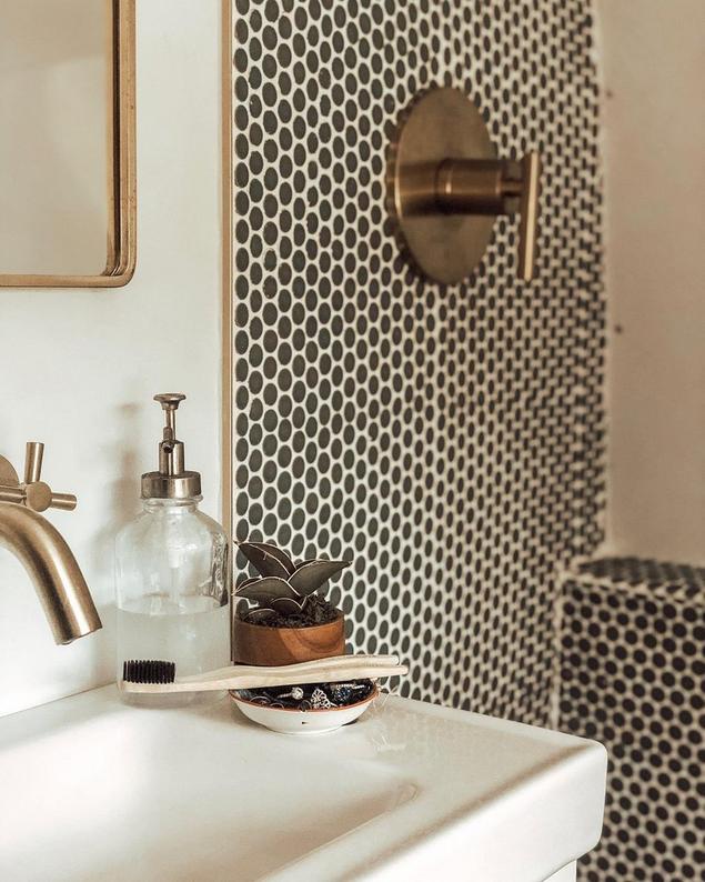 Midnight black porcelain penny tile covers a shower wall and floor.