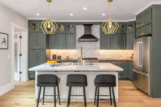 Unit with green kitchen cabinetry and white oak engineered hardwood flooring. 