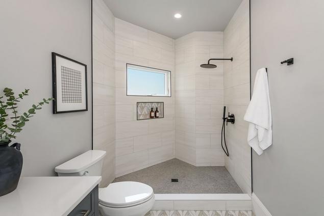 Bathroom with polished marble mosaic featured on the floors and in the shower niche.