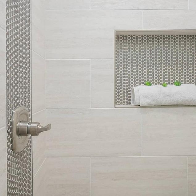 Matte Gray Porcelain Penny tile accents a shower niche and adjacent wall.