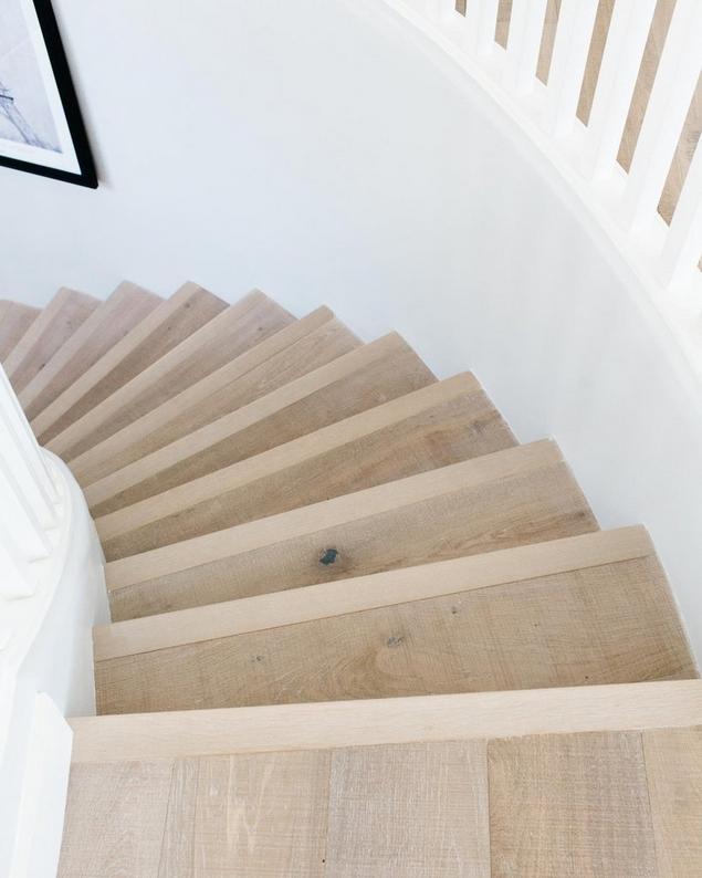 View from the top of a medium brown hardwood spiral staircase. 