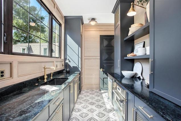 Stylish galley kitchen with patterned tile floors and dark cabinetry.