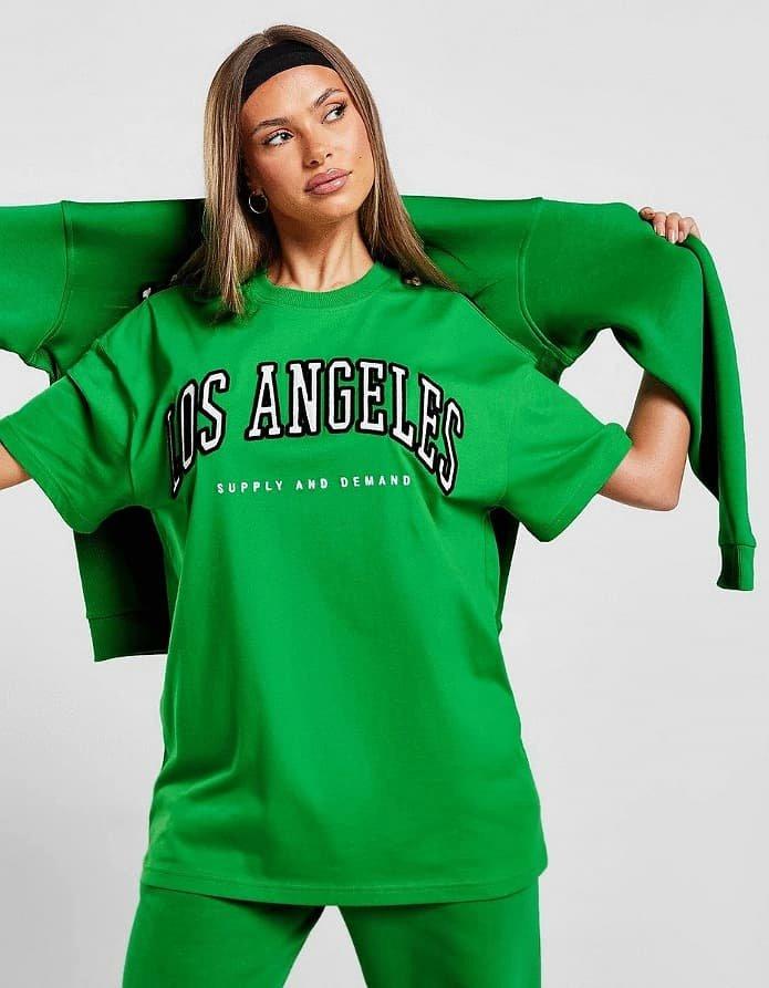 En person i gröna kläder med Los Angeles-tryck på bröstet