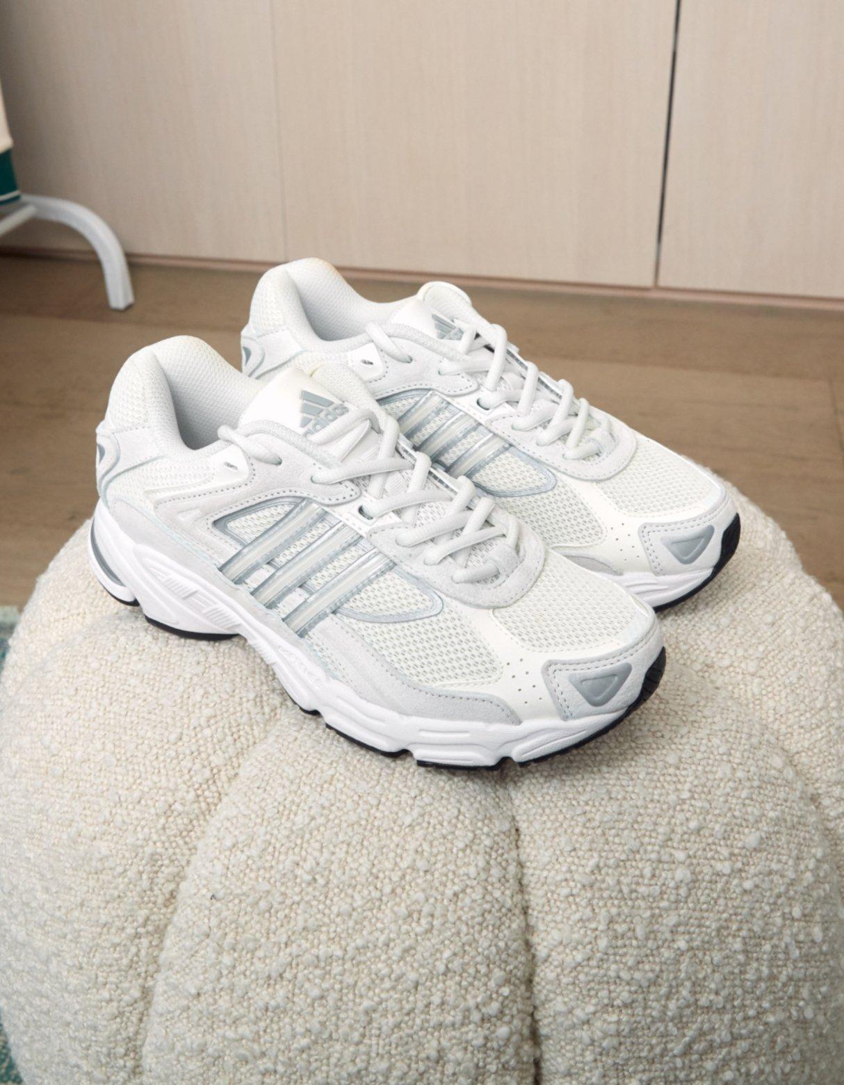 ett par adidas Response CL på en beige sittpuff