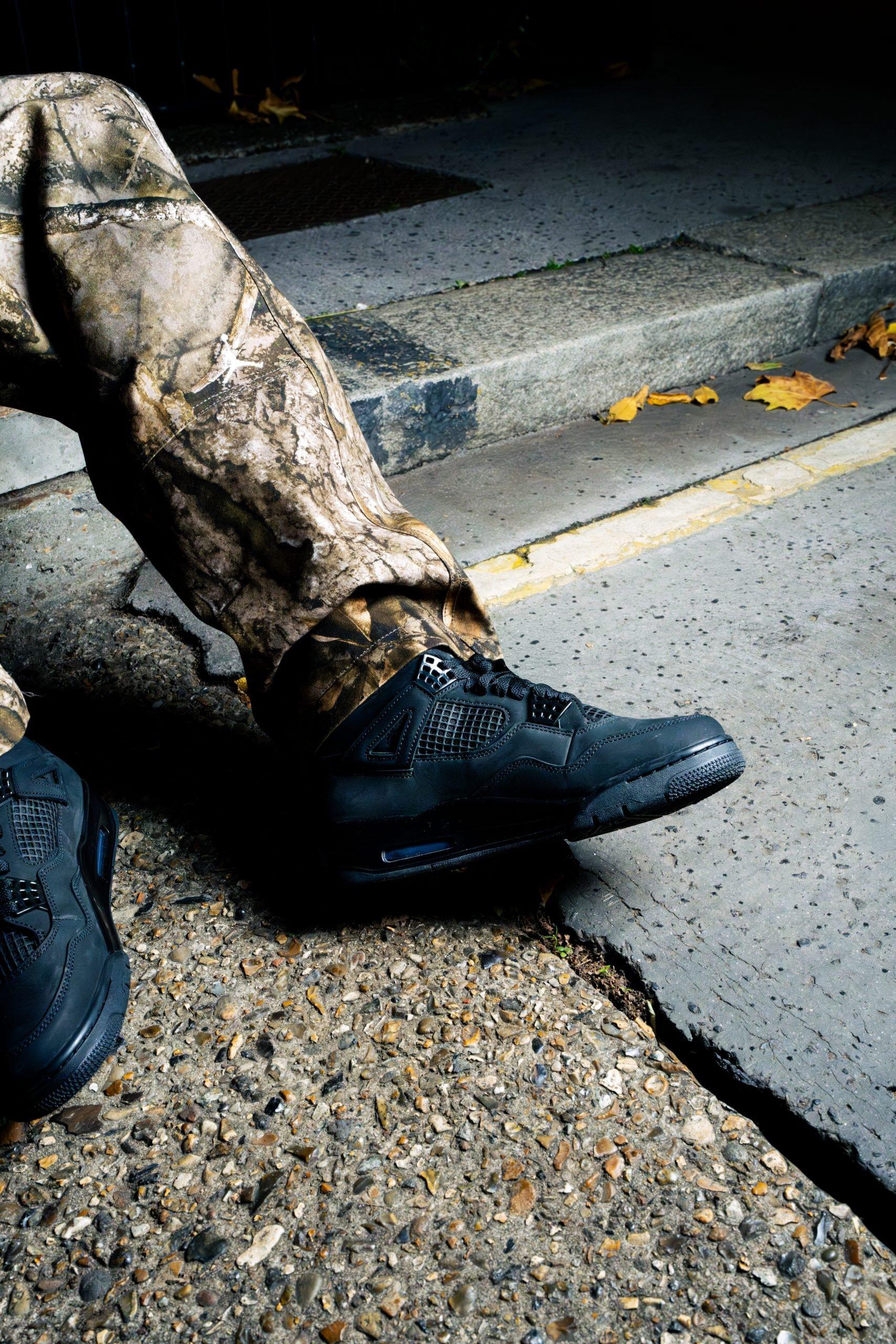 Close-up Air Jordan 4 Black Cat sur fond sombre