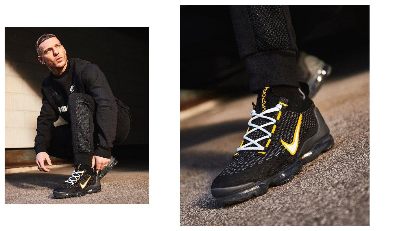 person wearing black clothes and a pair of Nike Air VaporMax with gold accents