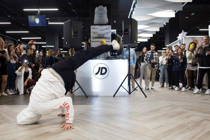 una persona haciendo breakdance en el suelo vestido de color blanco