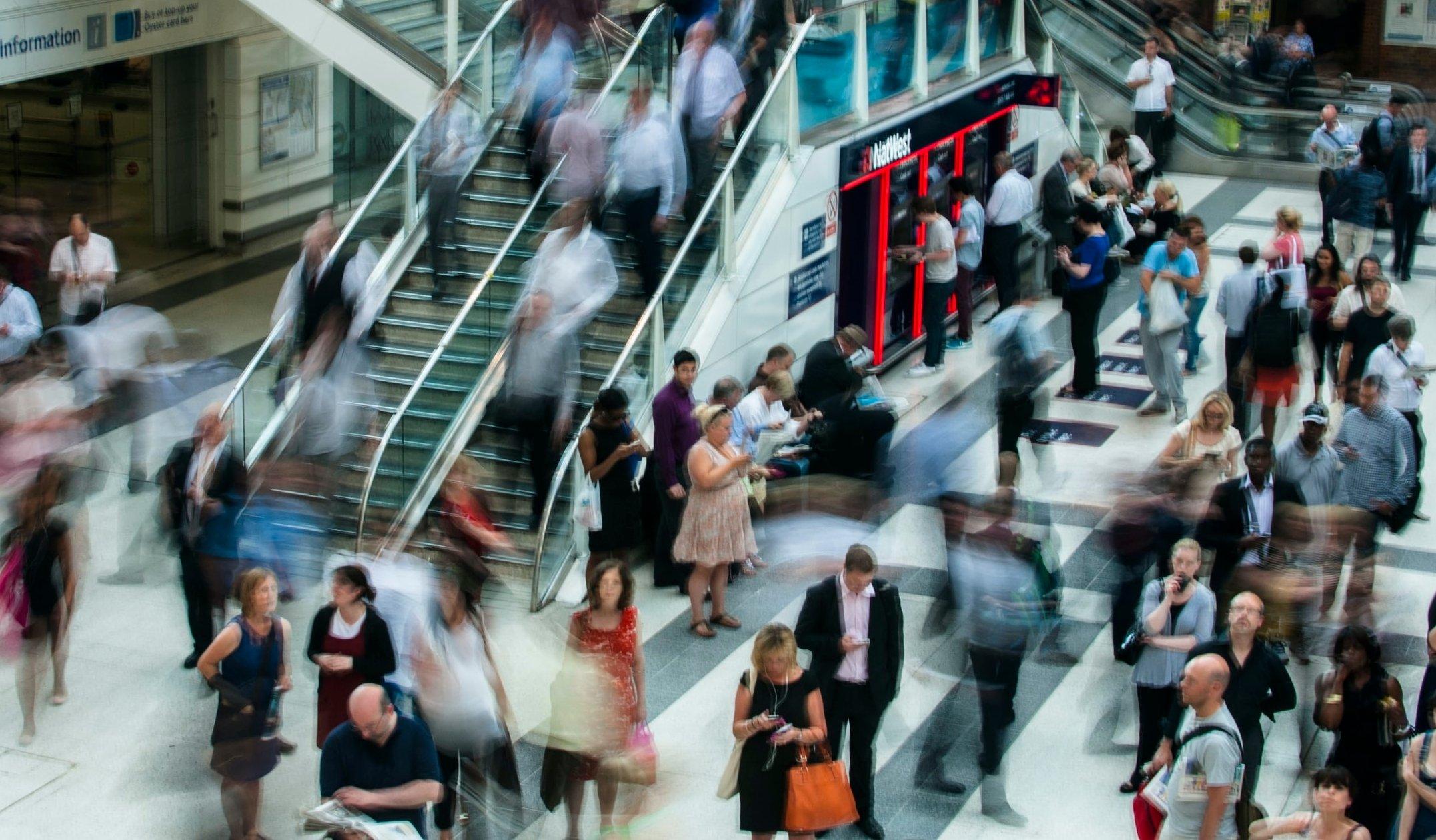 blurry image of a crowd of people rushing at a station