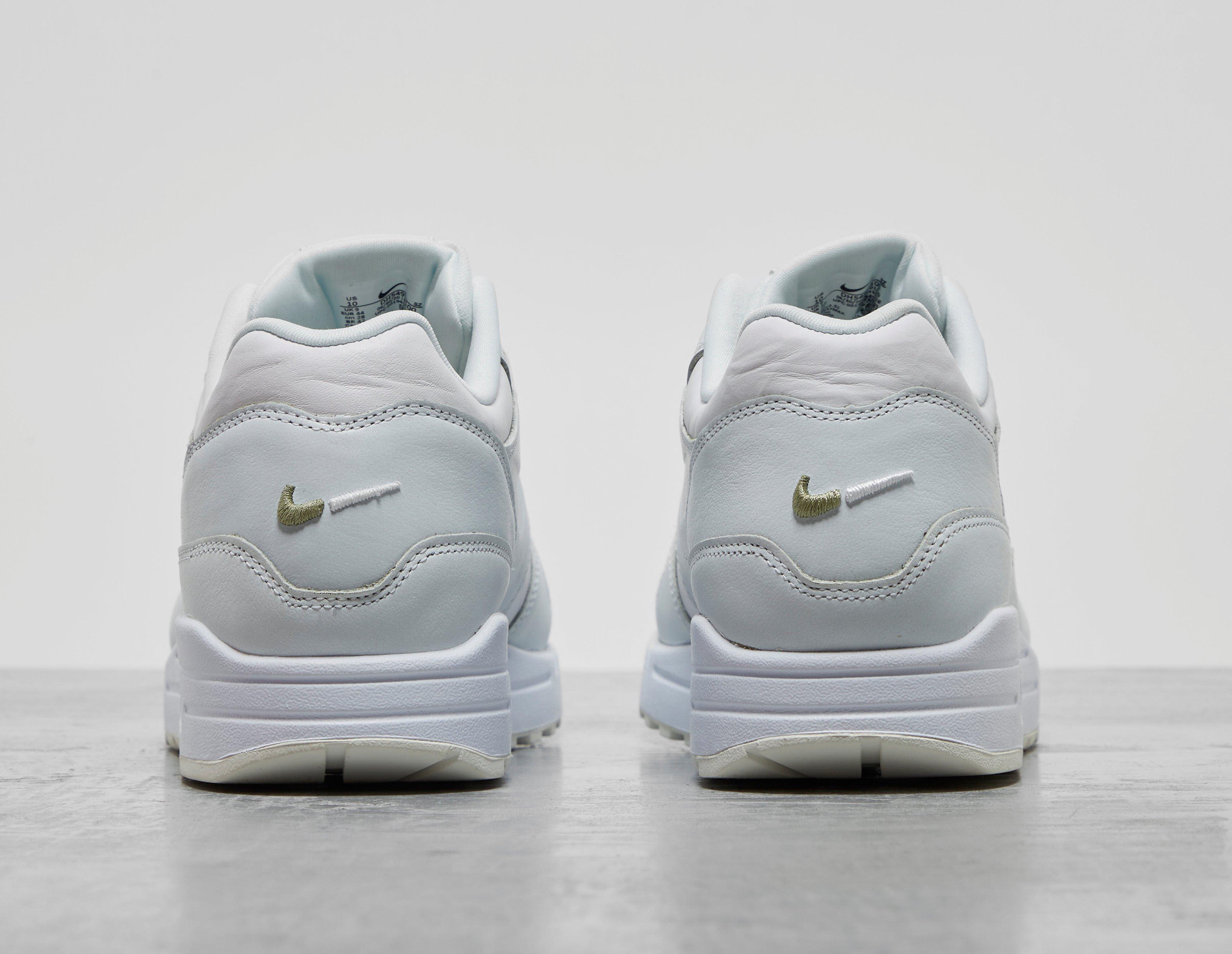 white nike shoes with orange swoosh