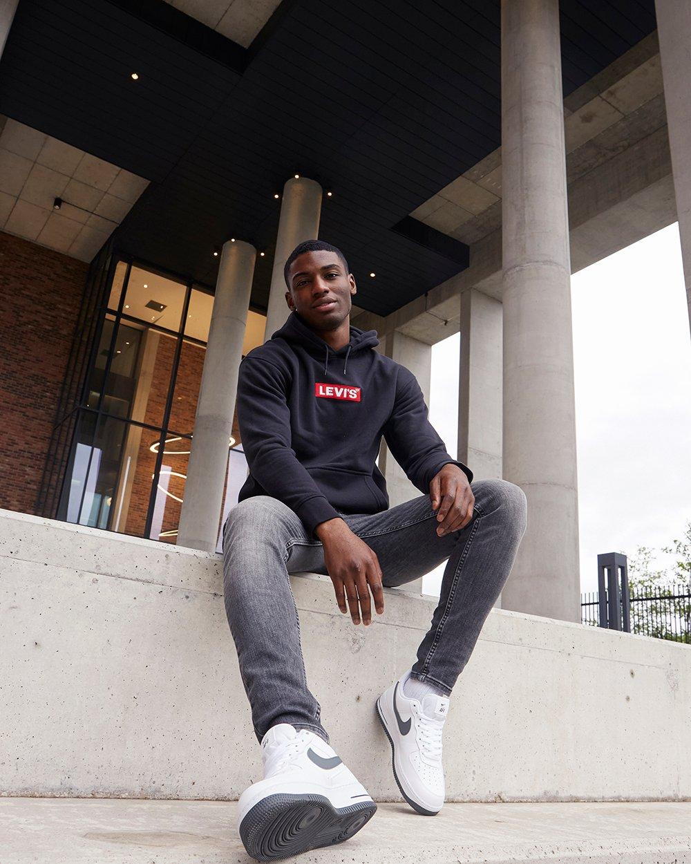 Mann mit schwarzer Skinny Jeans und Hoodie von Levi’s