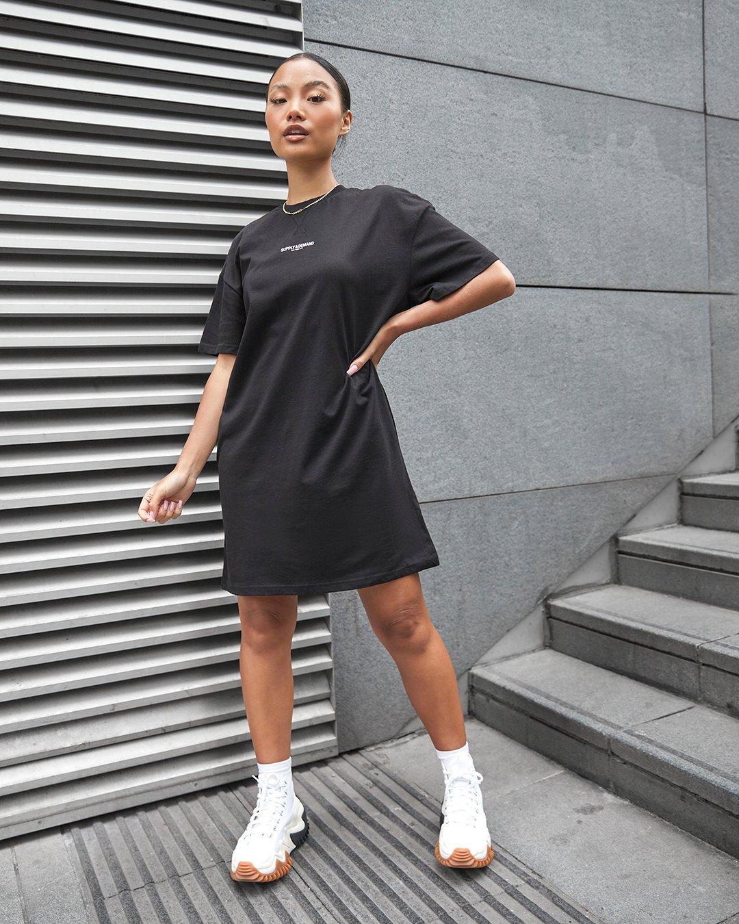 Frau in schwarzem T-Shirt Kleid von Supply & Demand