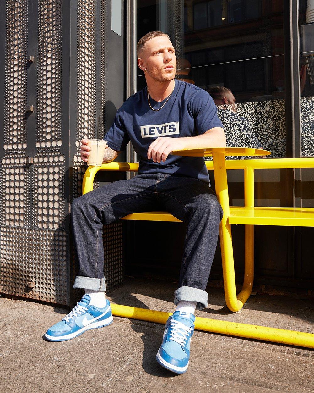 Mann in dunkelblauer Levis Jeans und Levi’s T-Shirt