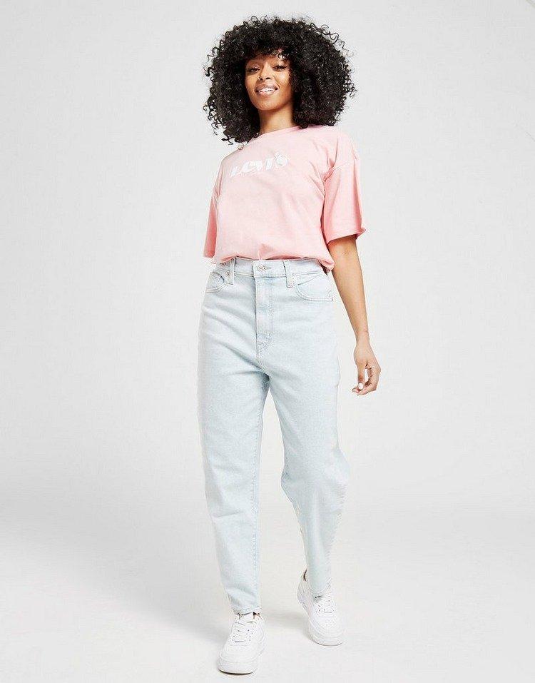 Frau mit High Waist Mom Jeans in hellem Denim und Levi’s T-Shirt in Rosa