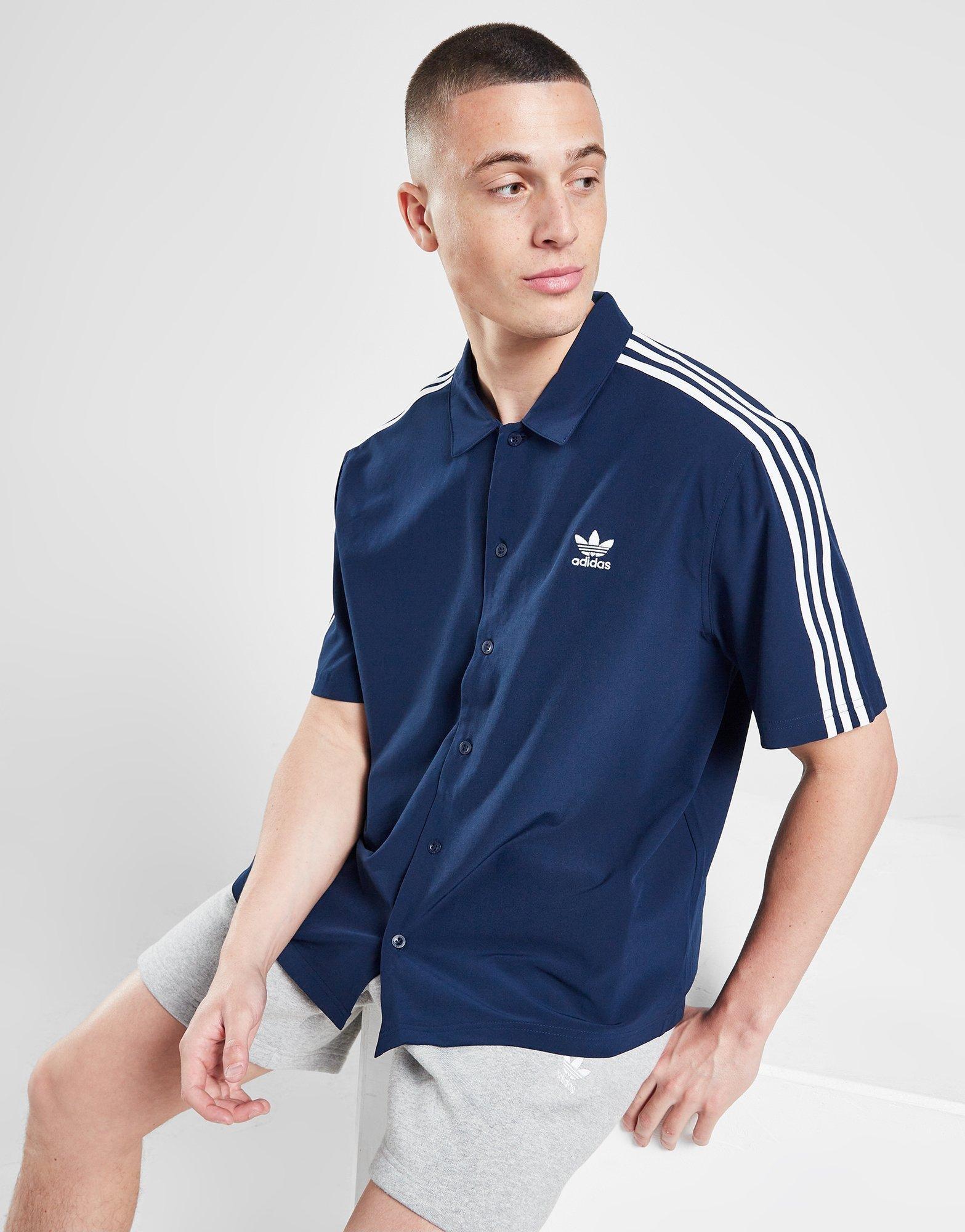 en person i lös mörkblå skjorta från adidas