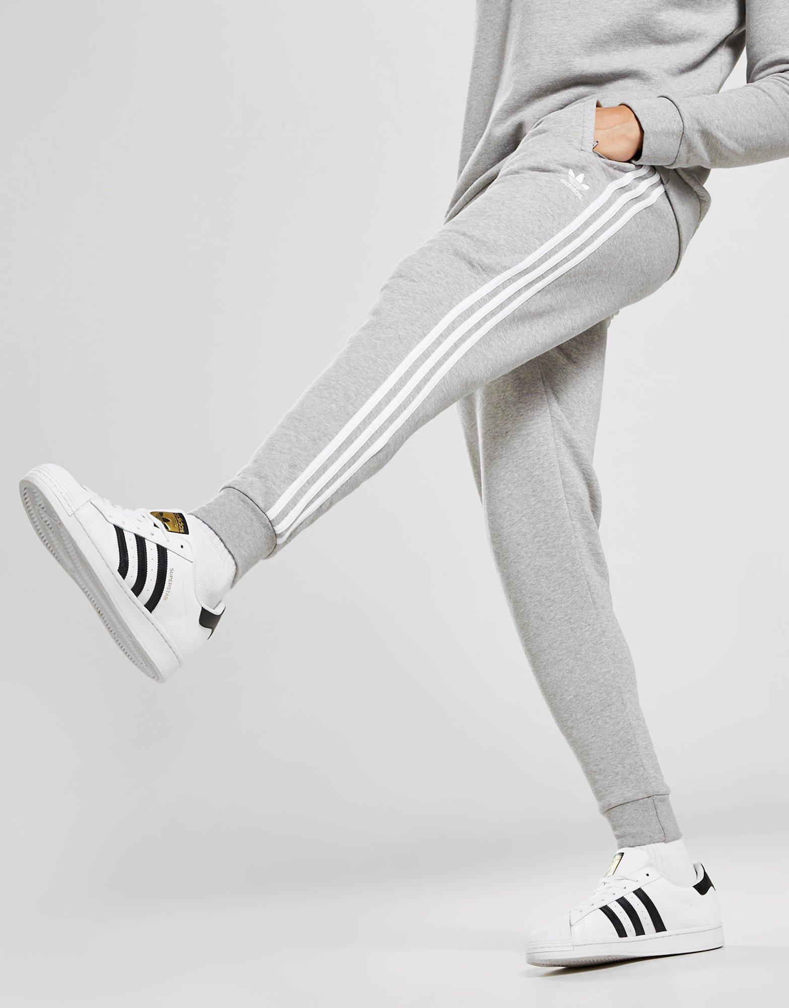 grey adidas joggers with black stripes