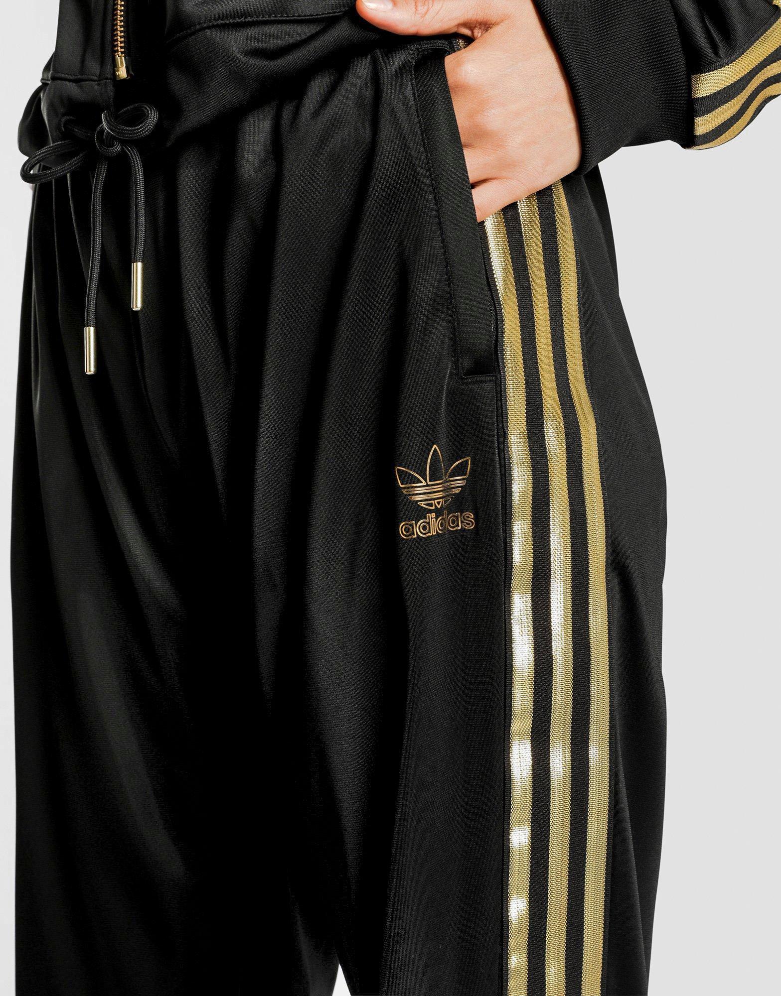 black adidas tracksuit with gold stripes